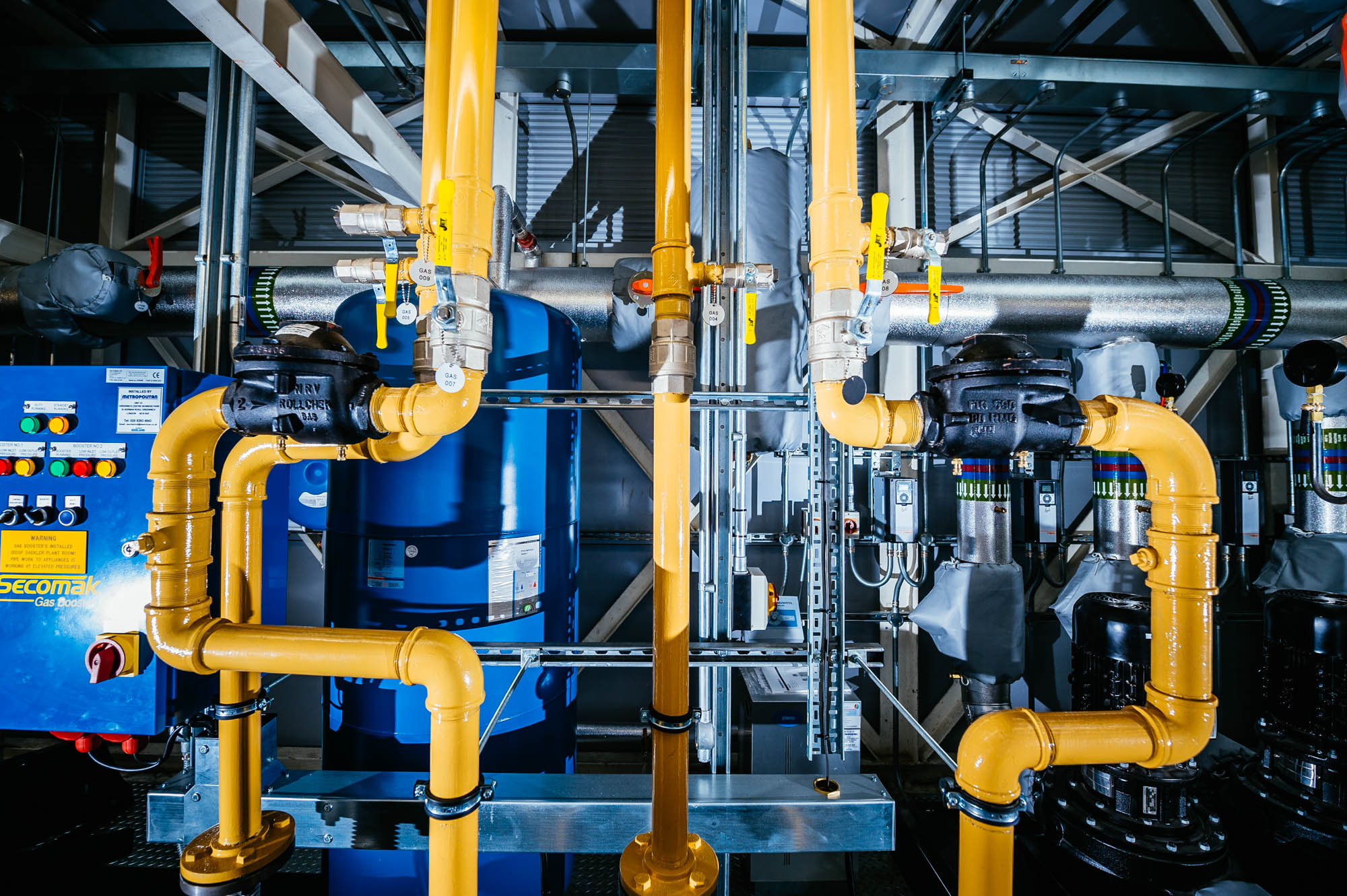 A photo of yellow and blue pipework at above an art gallery