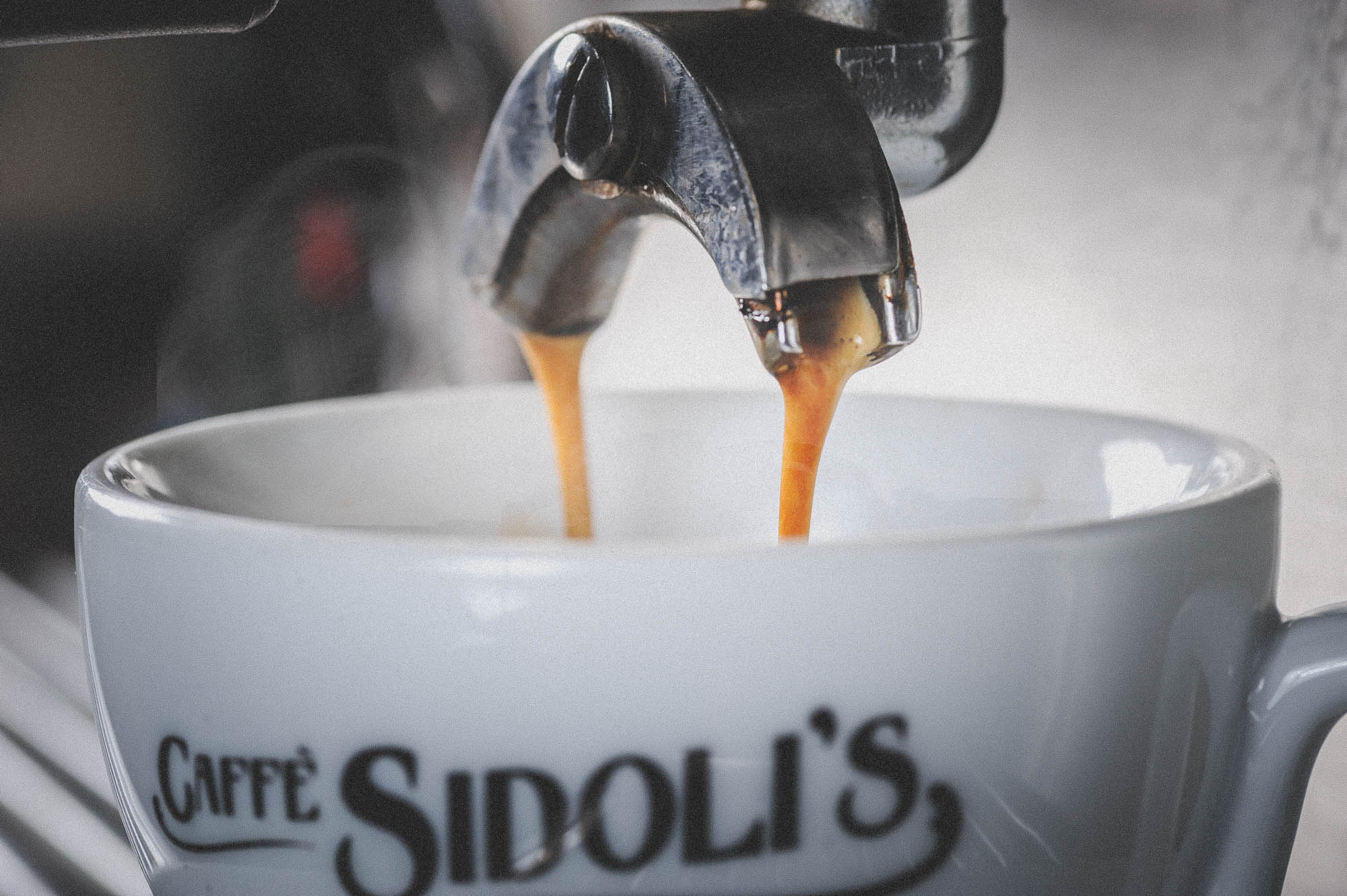 A photo of espresso coffee pouring and steaming into a cup